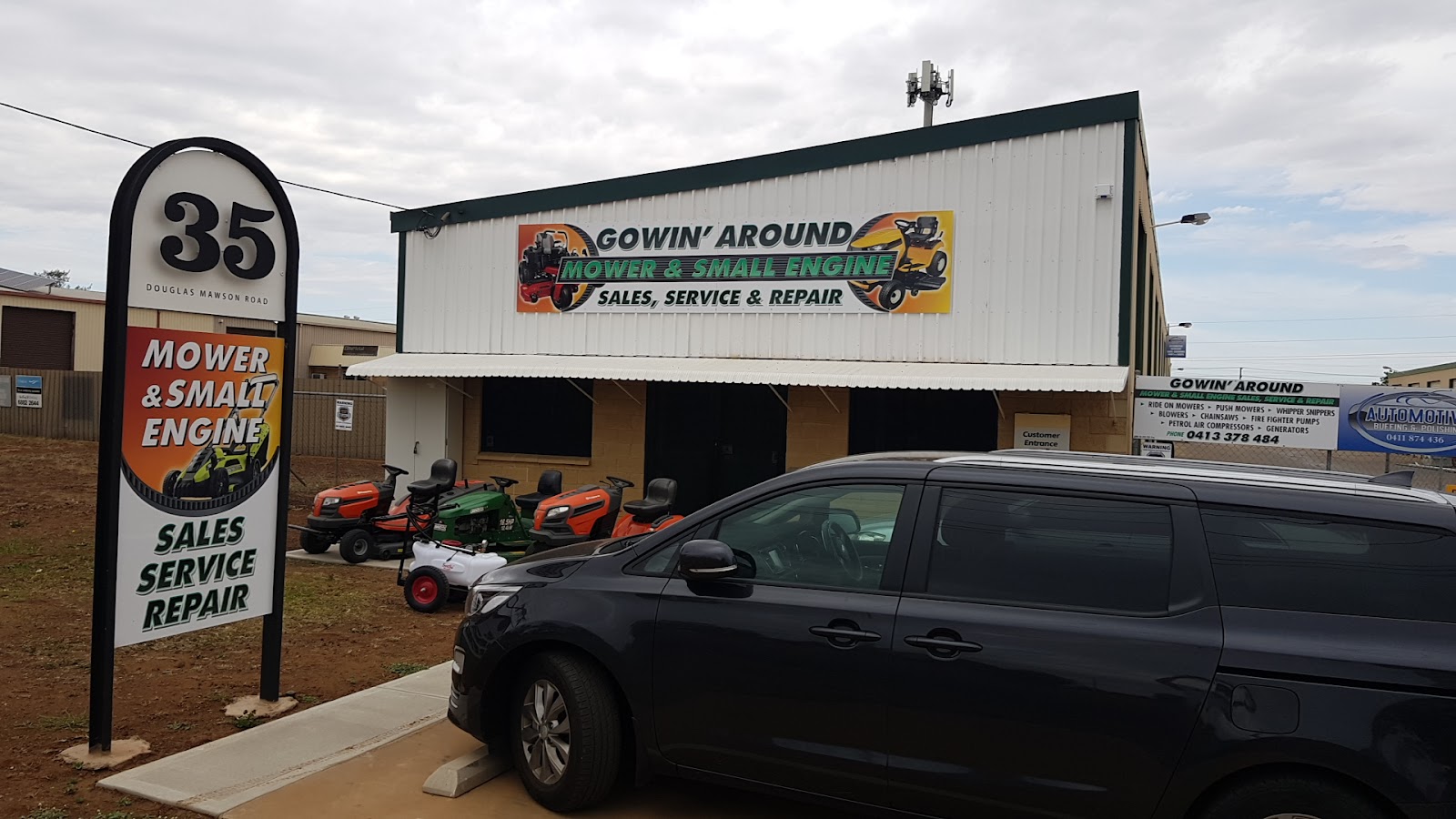 The Gowin’ Around shed with its pylon sign and the signboard listing ride on mowers, push mowers, whipper snippers, blowers, chainsaws, fire fighter pumps, petrol air compressors and generators